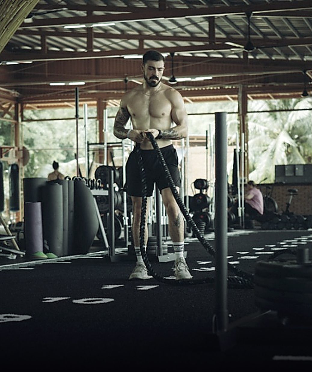 Jared training with battle ropes in an open-air gym