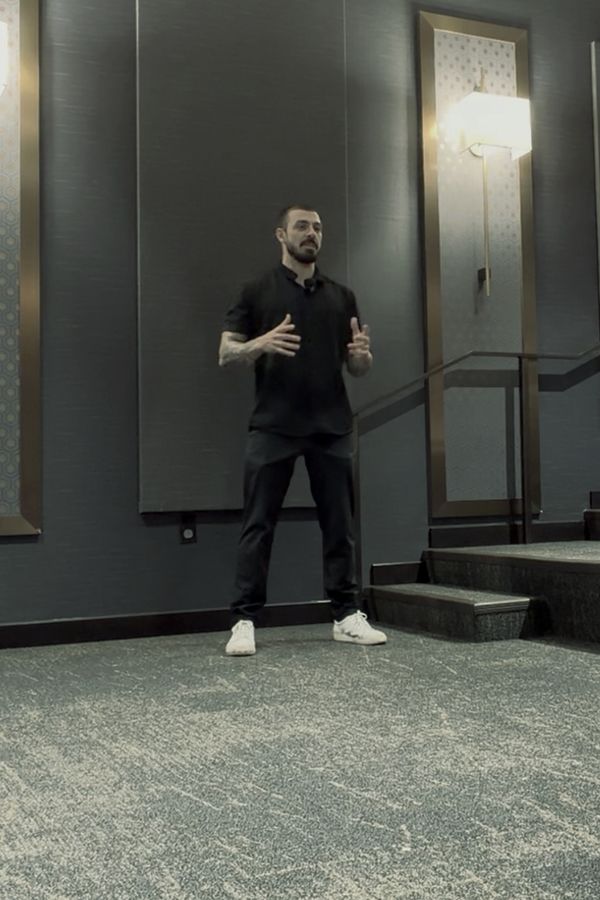Jared speaking to a room, on camera